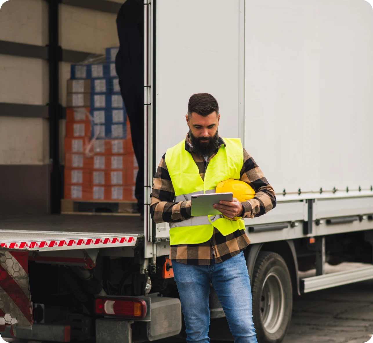 Logistics worker in safety vest with tablet